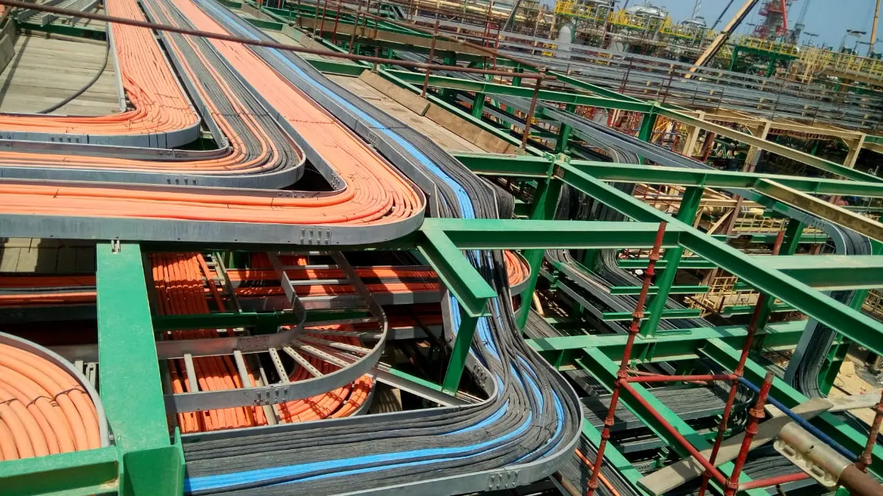 Cable trays carrying power and instrument cables across a pipe rack