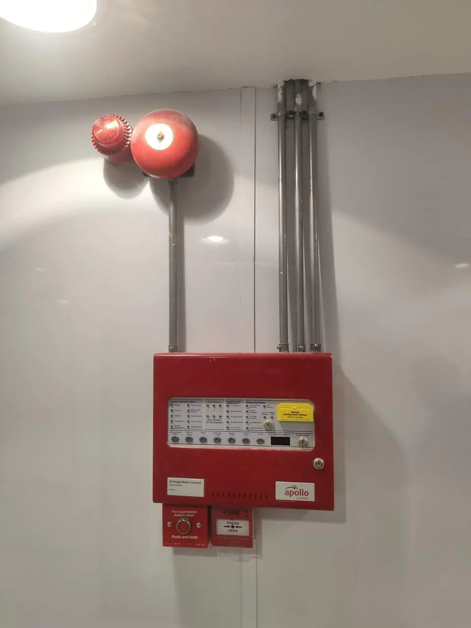 Fire alarm control panel with bell mounted on a corridor wall