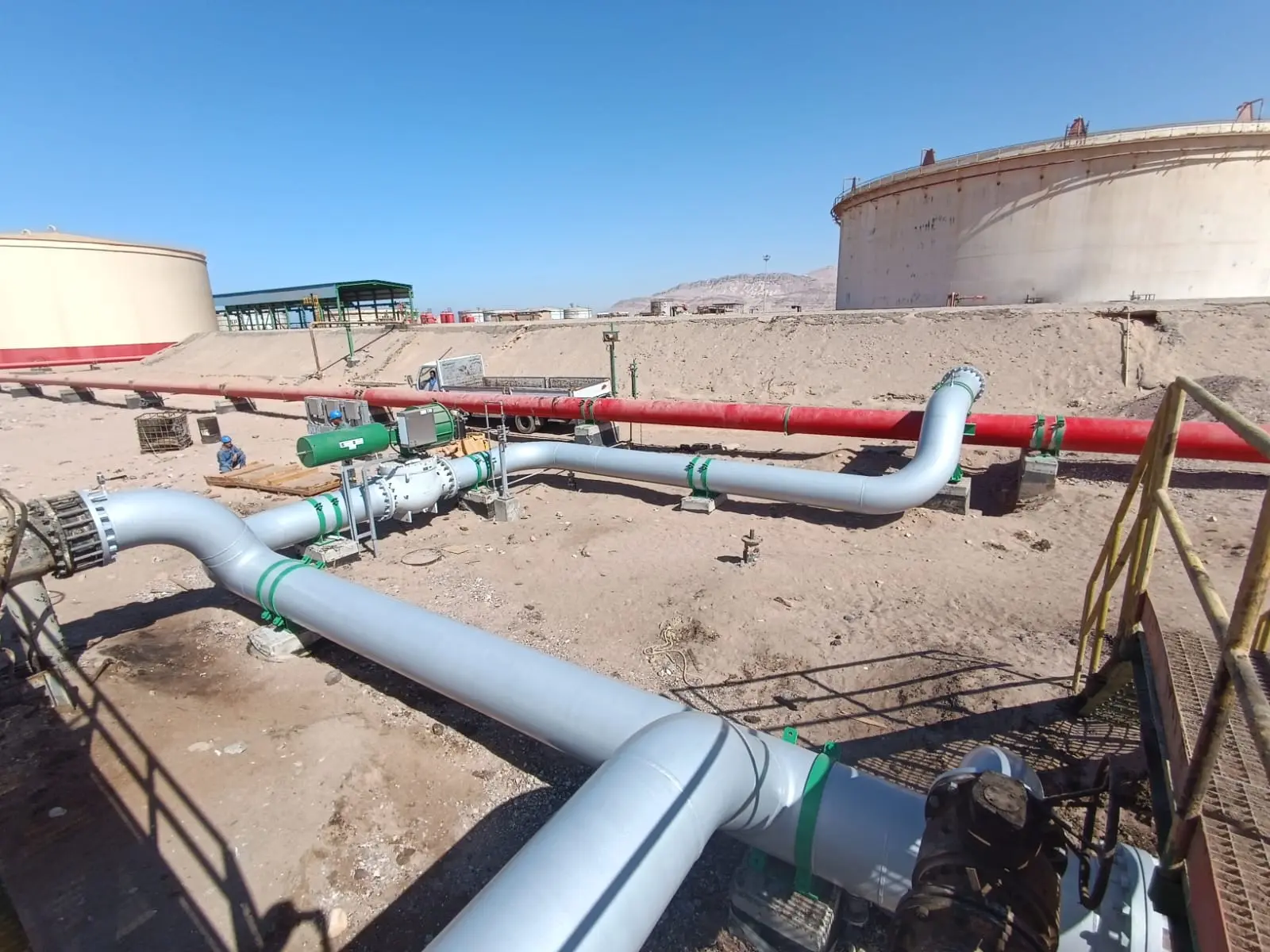 New process piping running between storage tanks