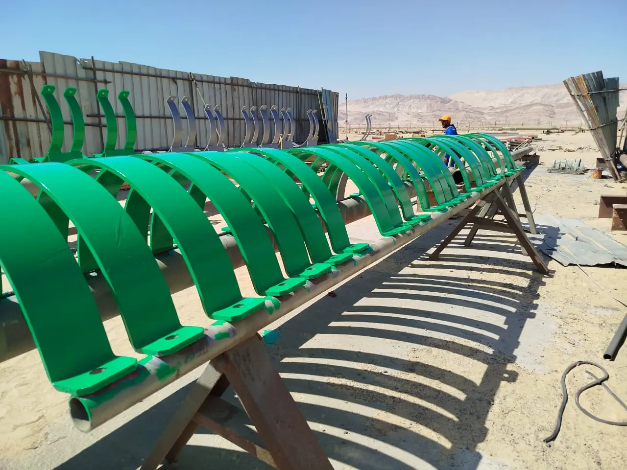 Row of fabricated pipe supports painted green