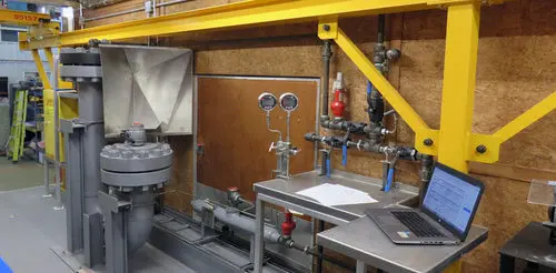 Instrument test bench with pressure gauges and a laptop