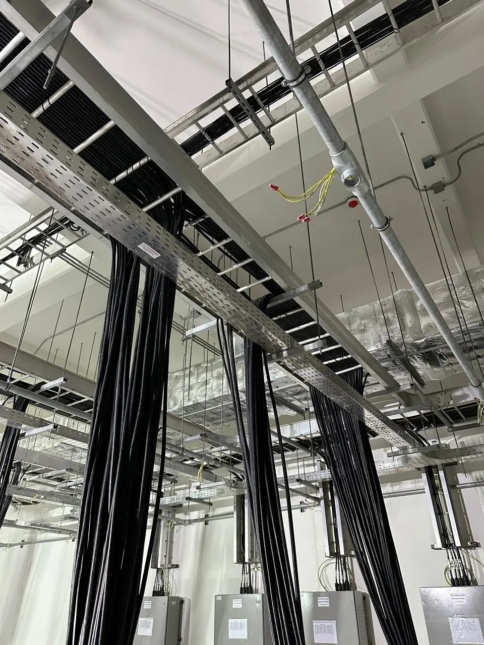 Overhead cable trays carrying neatly routed power cables in a plant room
